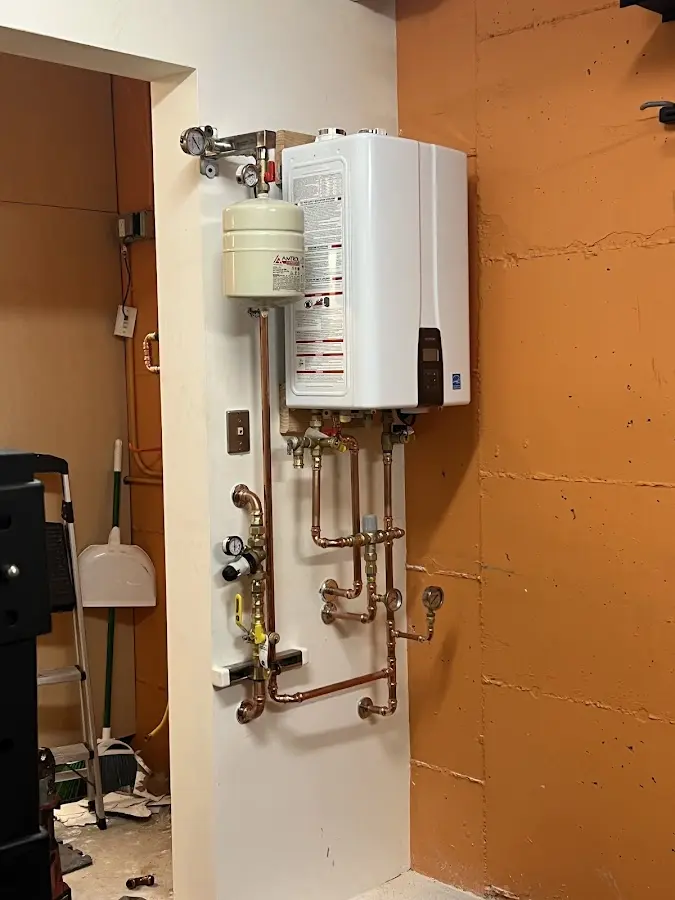 Plumbing technician inspecting water heater connections in Shiloh